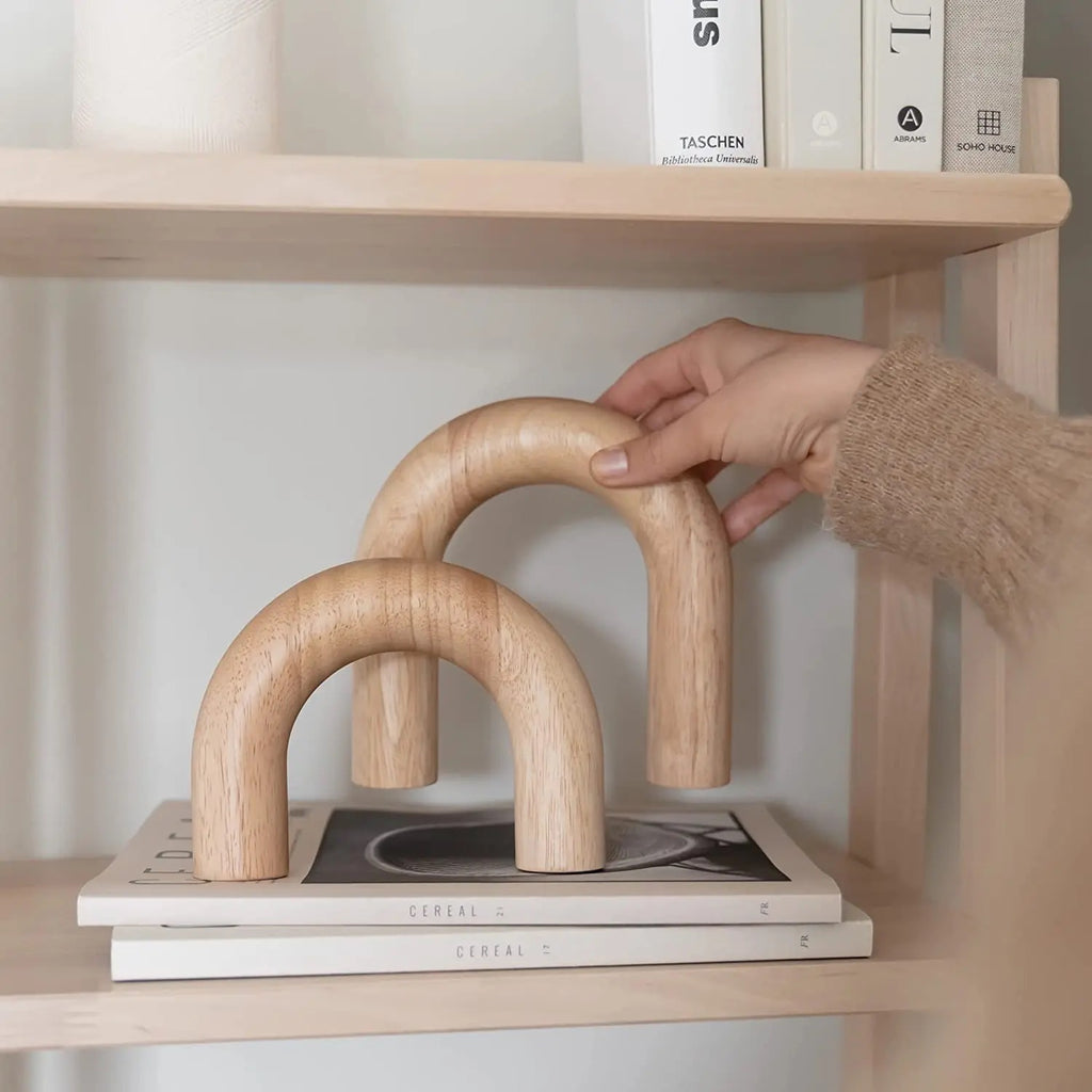 Decorative wooden arches placed atop a coffee table book for an elegant decor